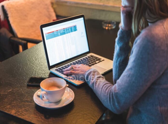 focused_180518154-stock-photo-cropped-shot-woman-cafe-typing
